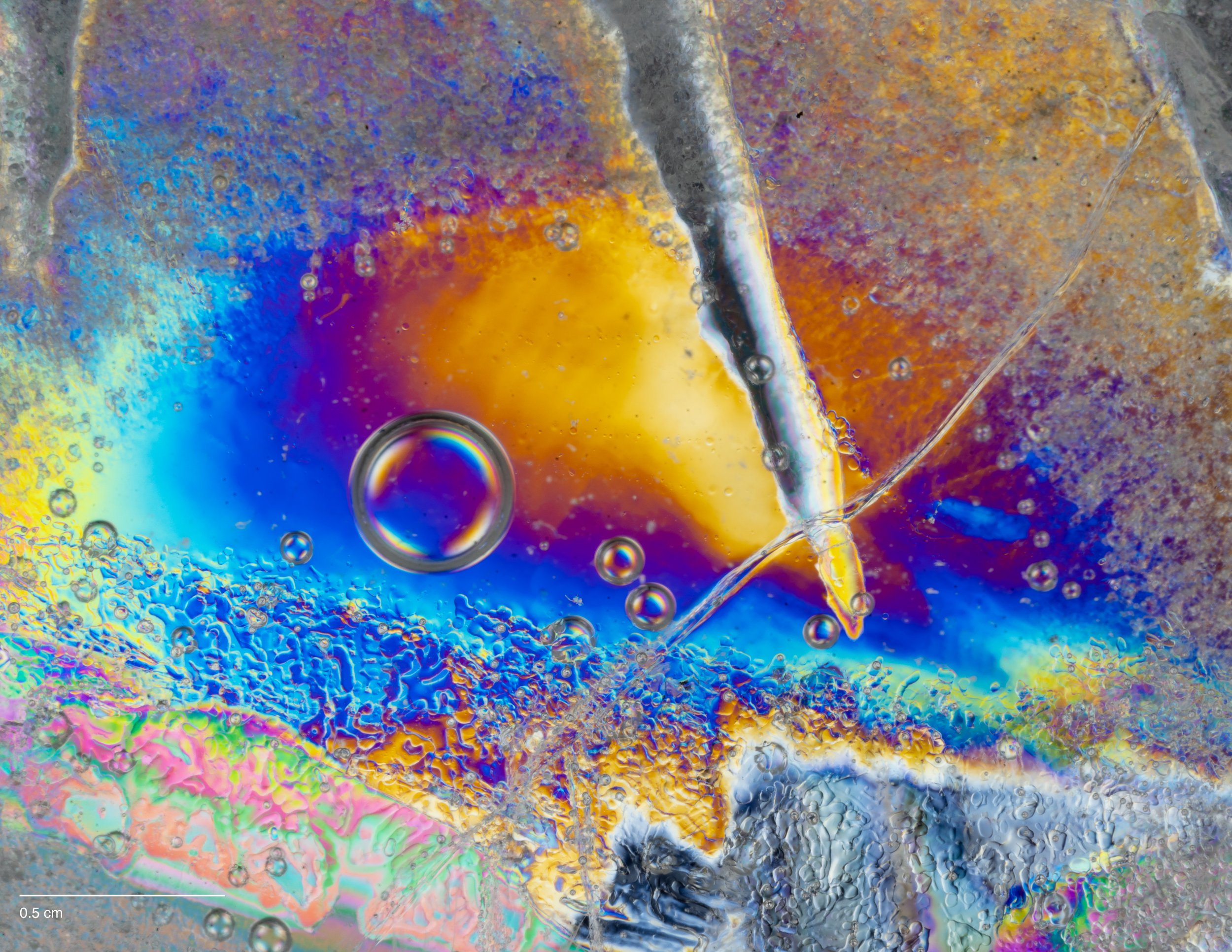 Microscopic cross-polarization of ice with bubbles and swirling patterns.