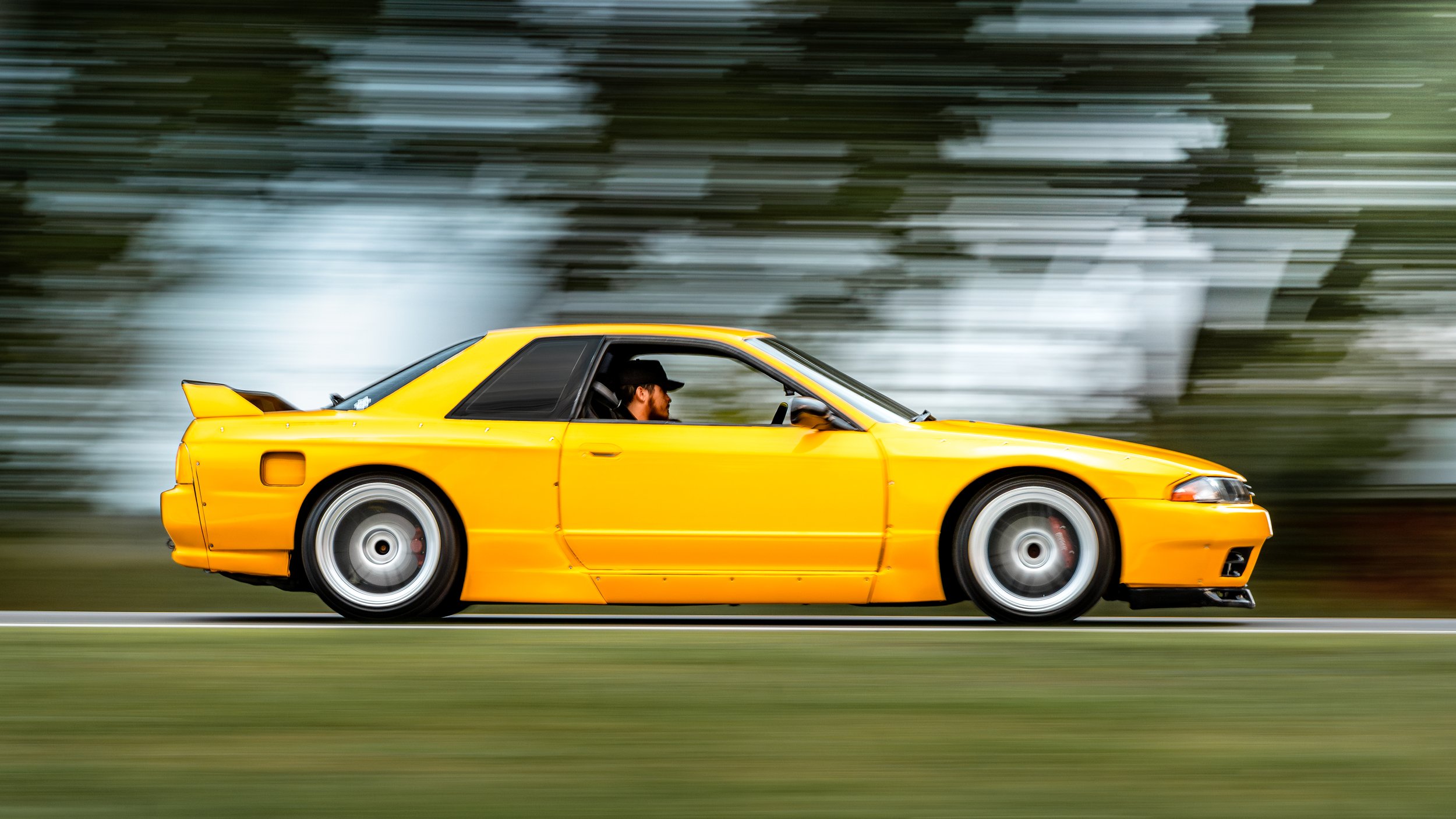 Yellow sports car in motion on a road with a blurred background